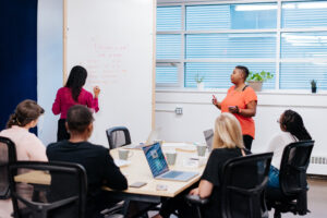 Animatrice donnant une formation marketing entreprise sur mesure à un groupe d'entrepreneurs